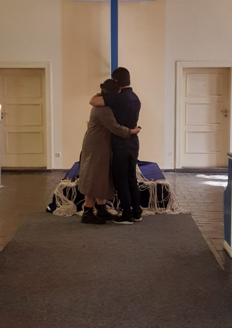 Kinder Bestattung. Umarmte Eltern eines verstorbenen Kinds bei der Beisetzung in der Kappelle.