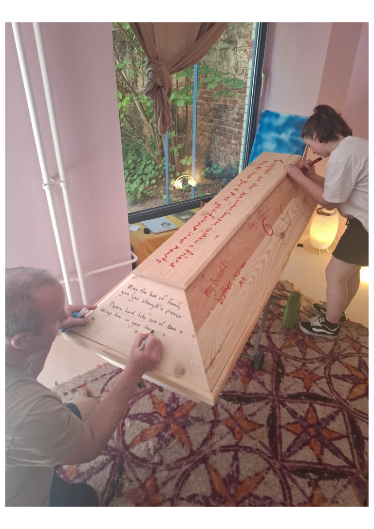 Ein Mann und eine Frau schreiben auf einem geschlossenen Holz Sarg