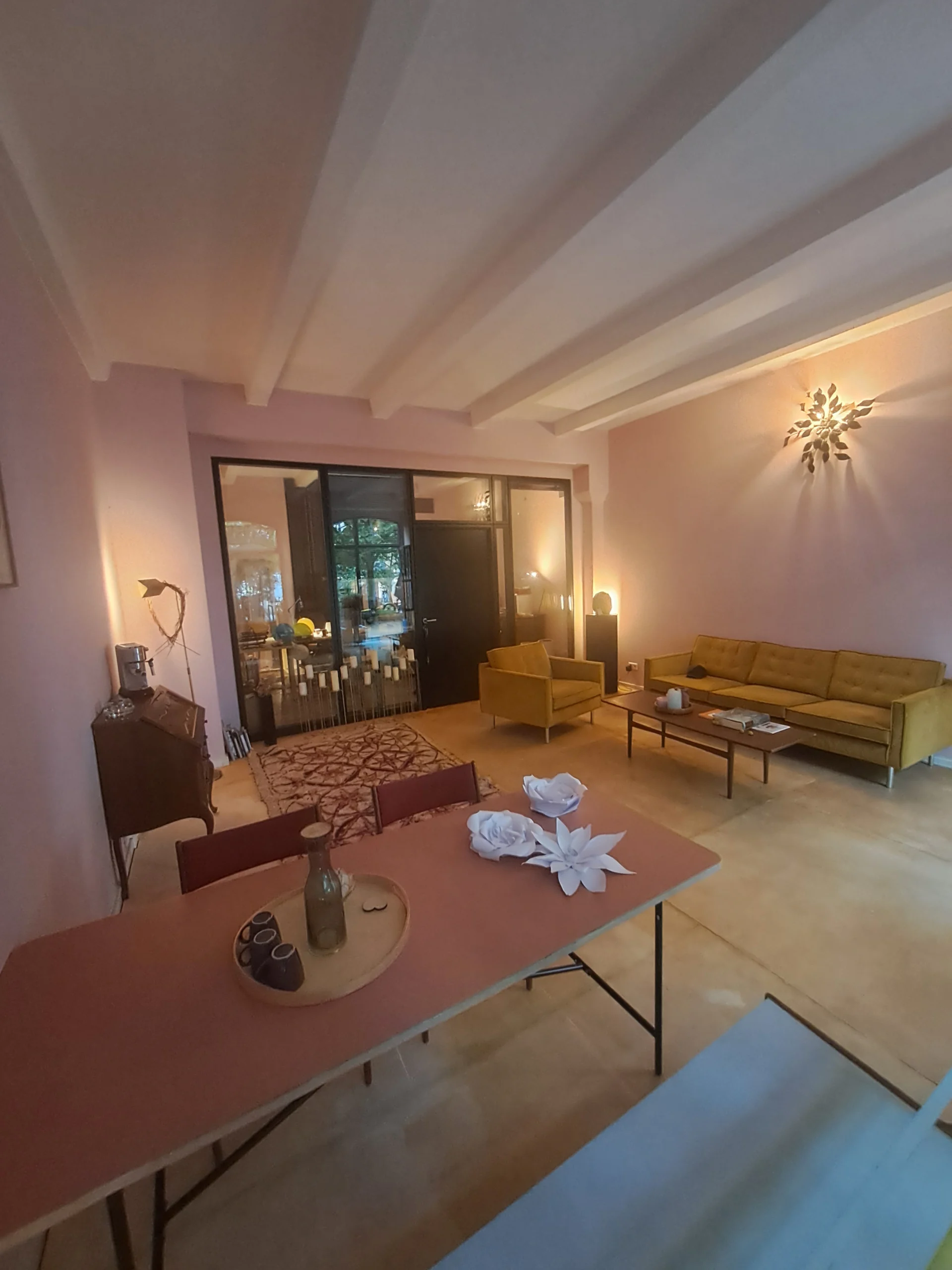 Ein Zimmer mit schönen helle Möbeln, zart rosa farbigen Wänden und gedimmtes Licht. Das ist das Ateleir AMgnolia Bestattungen in der Anklamer Str 38 in 10115 Berlin